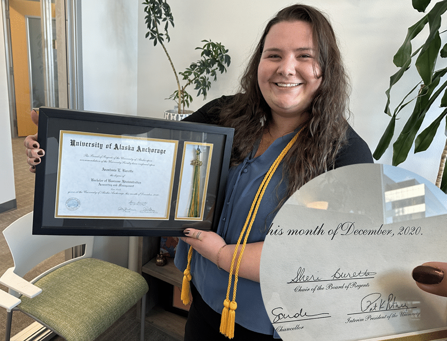 Anastasia Buretta holding up her UAA diploma